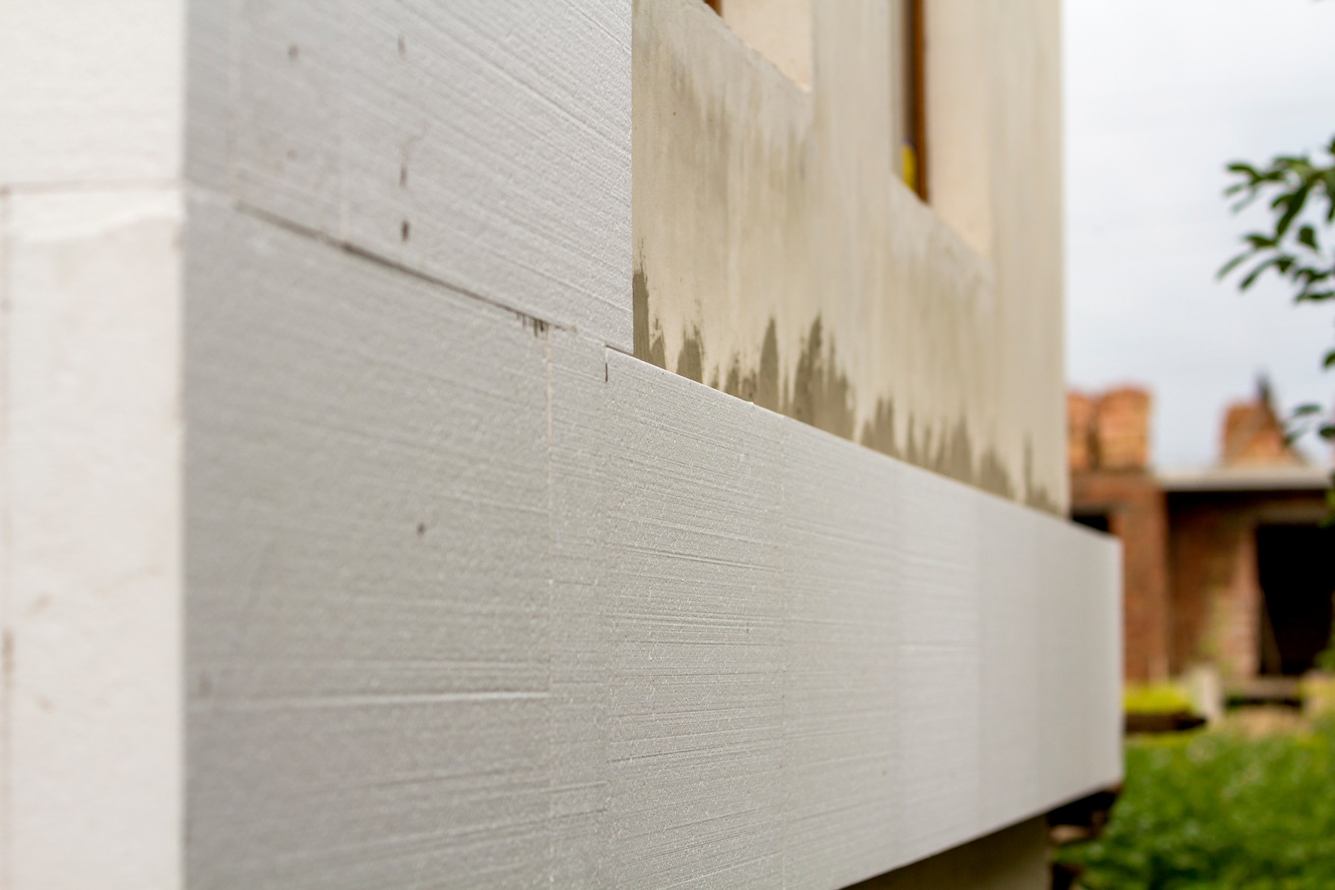 Détail de gros plan du mur de la maison plâtrée avec isolant de polystyrène rigide. La technologie moderne, construction, rénovation, économie d’énergie, alternative pour les laines minérales, notion chaleureuse maison confortable.